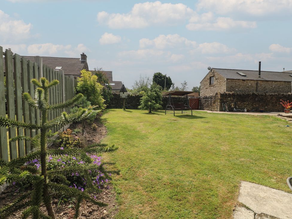 A garden with grass and a swing at Wigley House Farm Bungalow Chesterfield