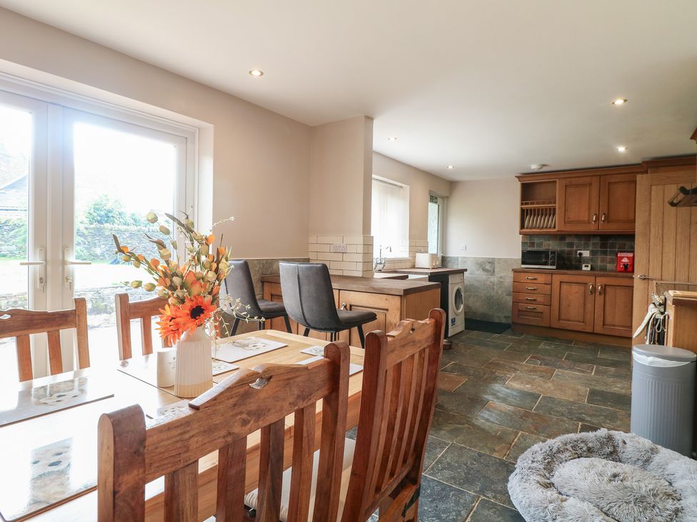 A kitchen with wooden furniture and appliances at Wigley Farm House Cottage Chesterfield