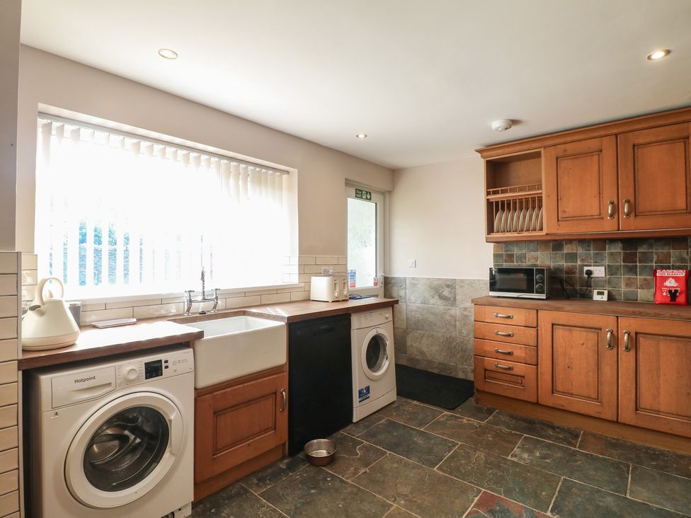 A kitchen with a washing machine and sink at Wigley Farm House Cottage in Chesterfield