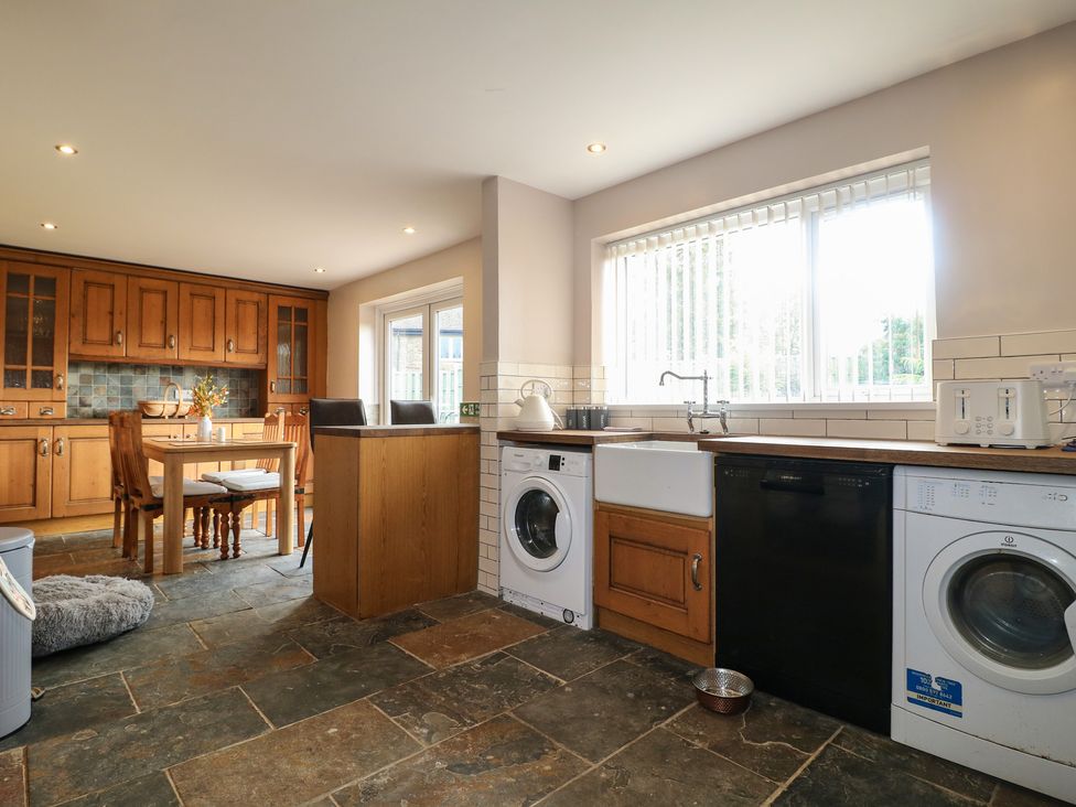 A kitchen with appliances and dining table at Wigley Farm House Cottage Chesterfield