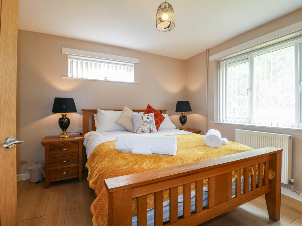 A bedroom with a bed and side tables at Wigley Farm House Cottage Chesterfield