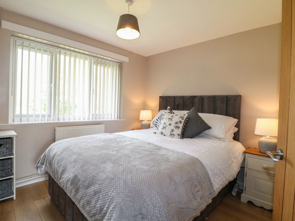 A bedroom with a bed and two lamps at Wigley Farm House Cottage Chesterfield