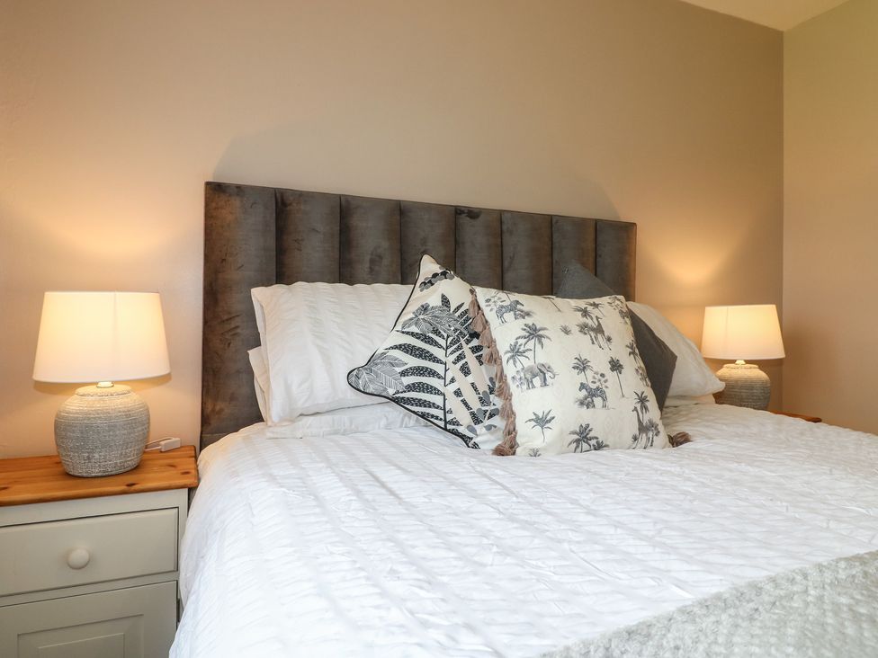 A bedroom with a bed and lamps at Wigley Farm House Cottage, Chesterfield