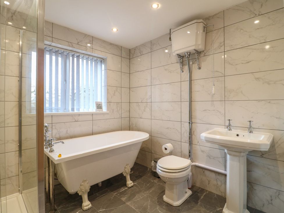 A bathroom with a bathtub, sink, and toilet at Wigley Farm House Cottage Chesterfield