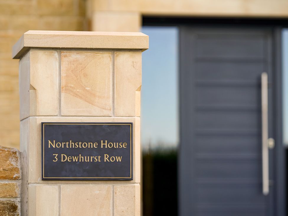 A nameplate on a stone column with a door at Northstone House in Blackburn