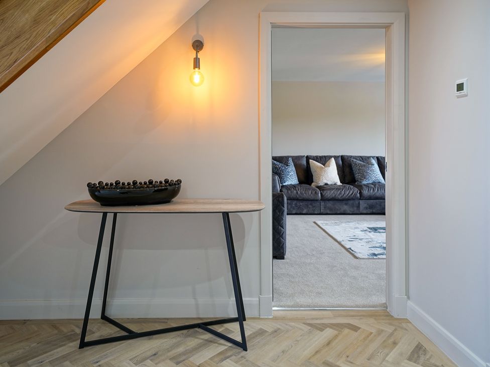 A hallway with a table and light fixture at Northstone House Blackburn