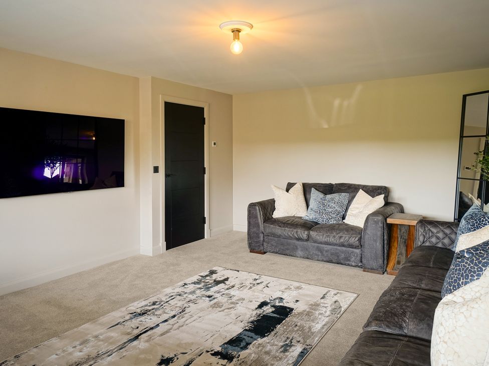 A living room with a sofa and television at Northstone House in Blackburn