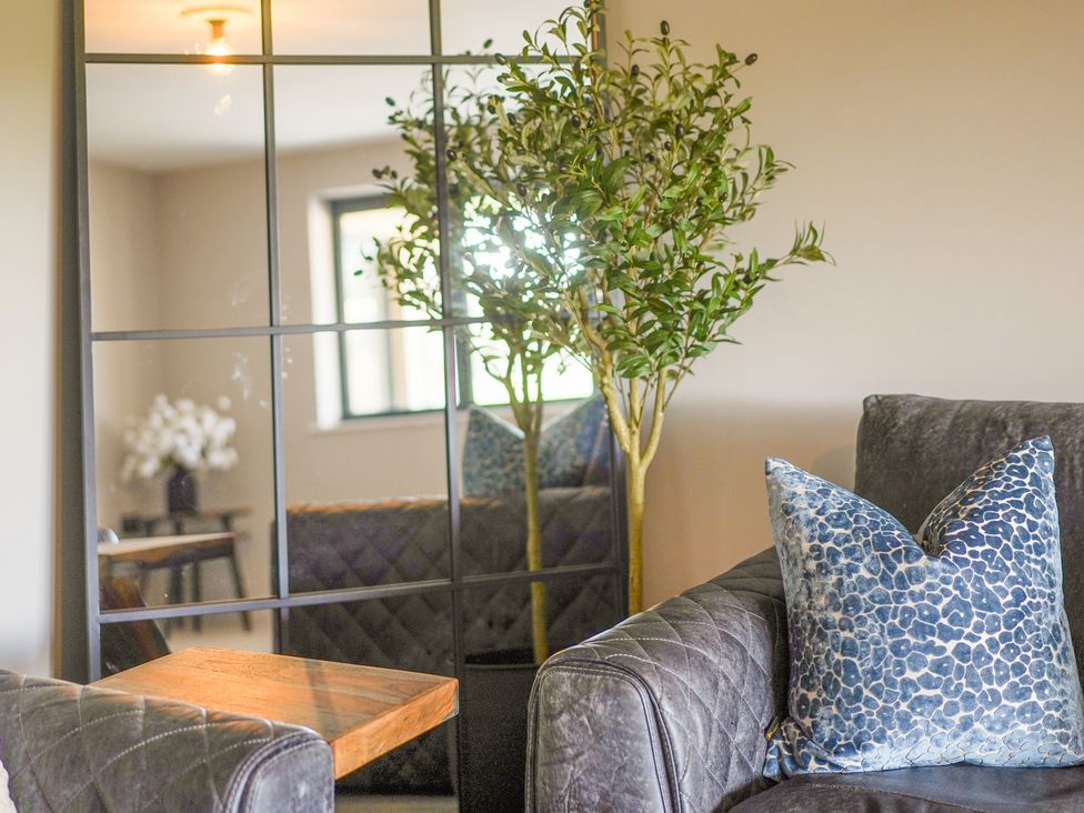 A living room with a sofa, table, and plant at Northstone House Blackburn