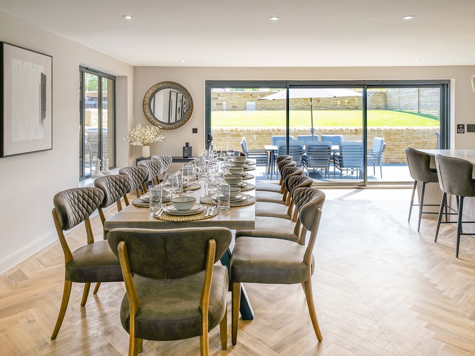 A dining room with a long table set for a meal at Northstone House Blackburn
