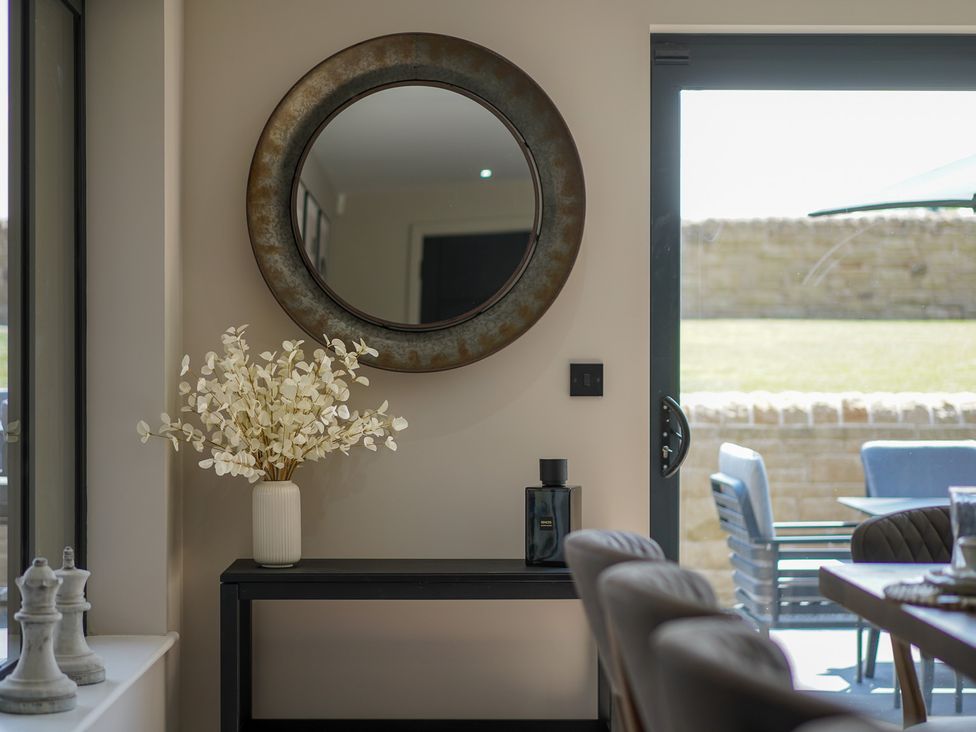 A console table with a mirror and decorative plant at Northstone House, Blackburn