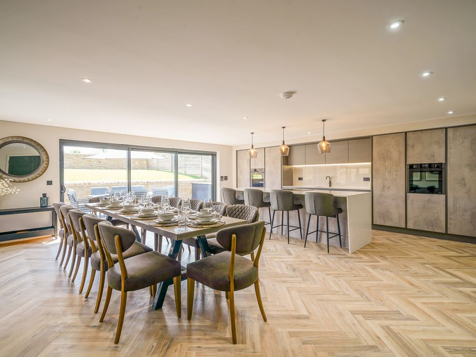 A dining room with a large table and kitchen island at Northstone House Blackburn