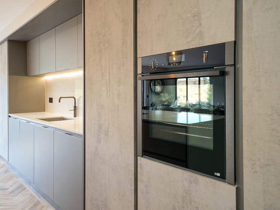 A kitchen with cabinets, sink, and oven at Northstone House Blackburn