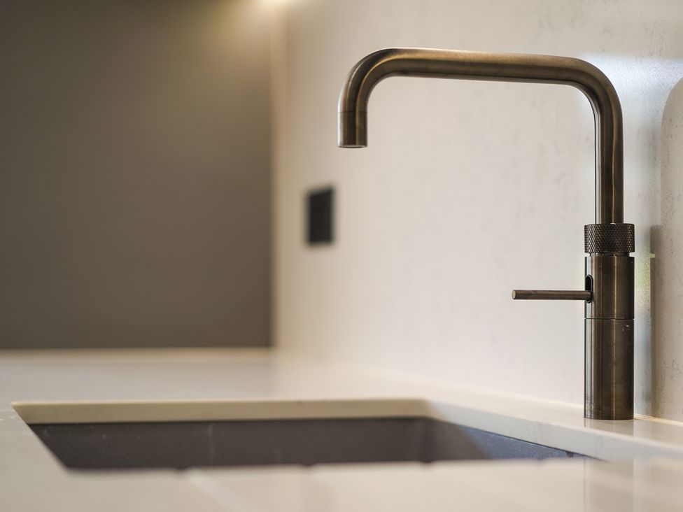 A faucet above a sink on a countertop at Northstone House Blackburn
