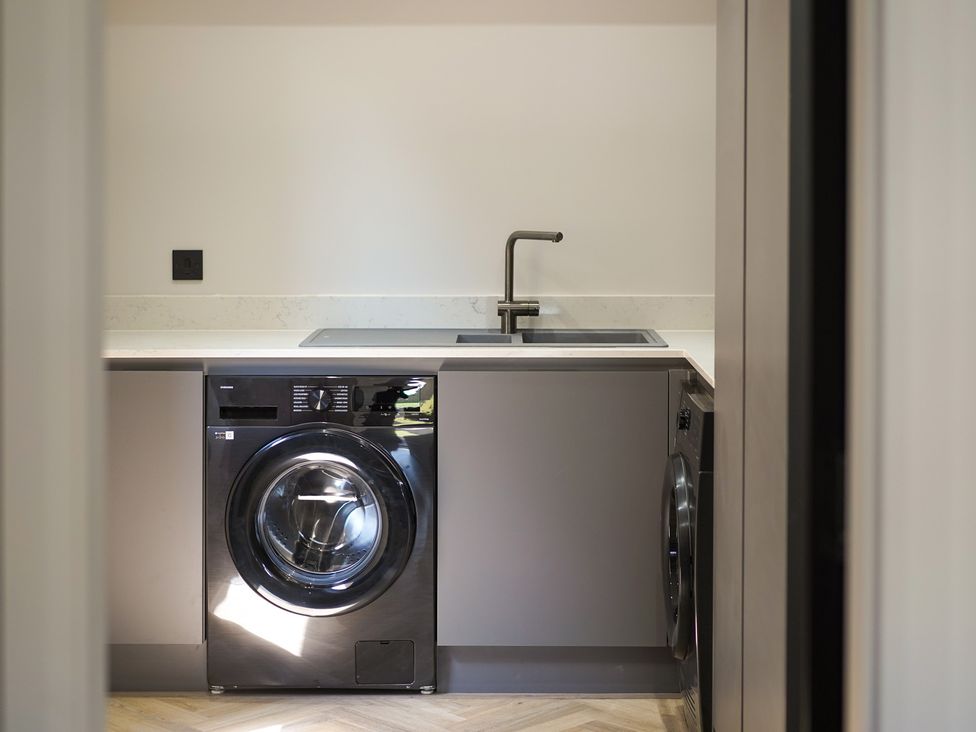A laundry room with a washing machine and sink at Northstone House Blackburn