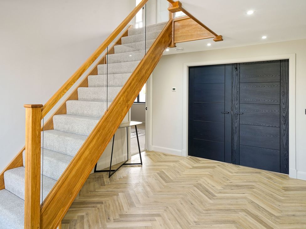 A hallway with stairs and a front door at Northstone House Blackburn