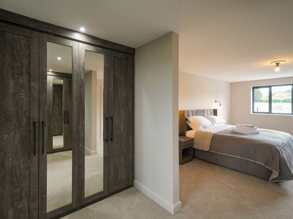 A bedroom with a bed and mirror wardrobe at Northstone House Blackburn