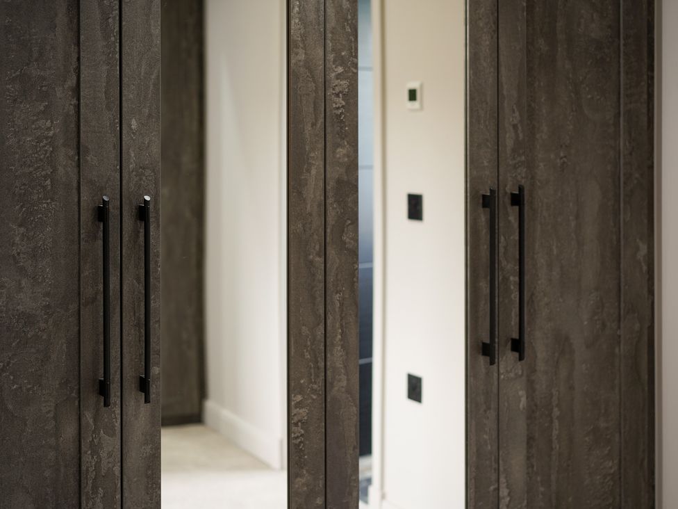 A wardrobe with mirrors in a bedroom at Northstone House Blackburn