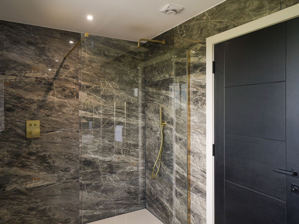 A shower area with glass panel and wall control at Northstone House Blackburn