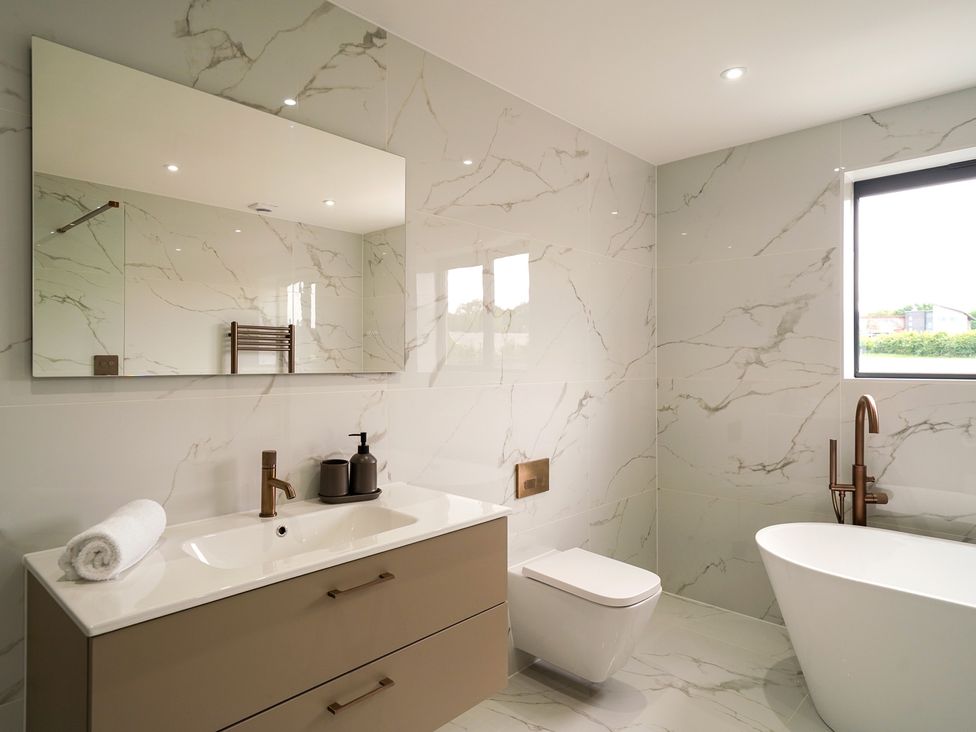 A bathroom with a bathtub, sink, and toilet at Northstone House in Blackburn