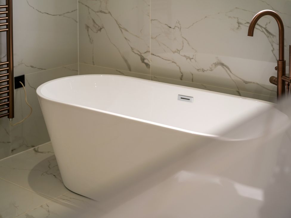 A bathroom with a freestanding bathtub and towel radiator at Northstone House Blackburn