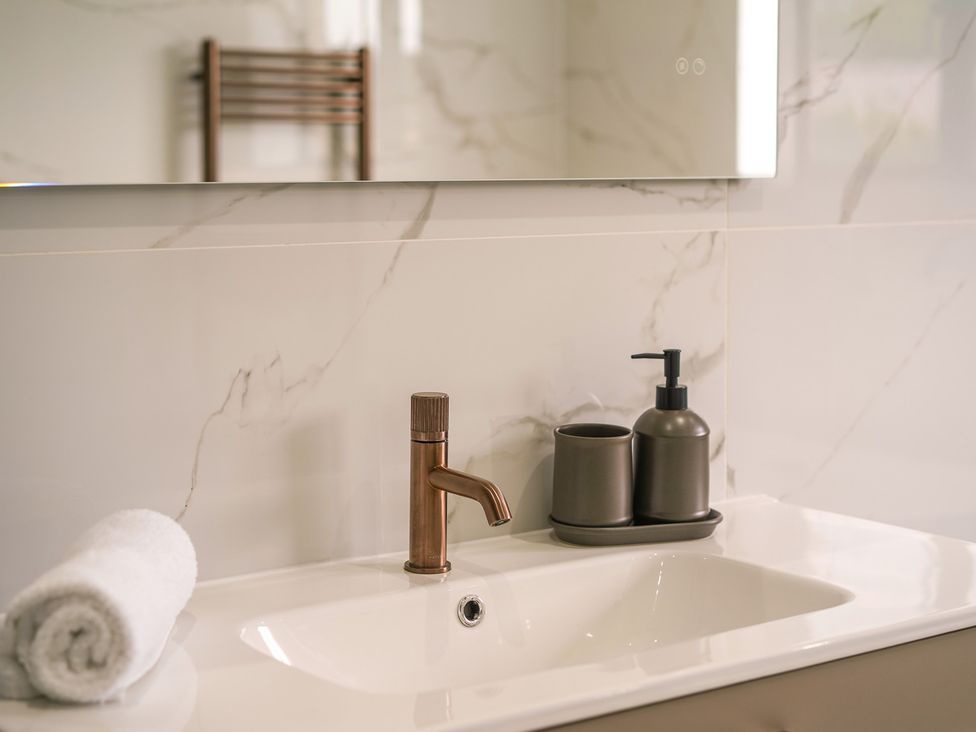 A bathroom sink with faucet and towels at Northstone House Blackburn
