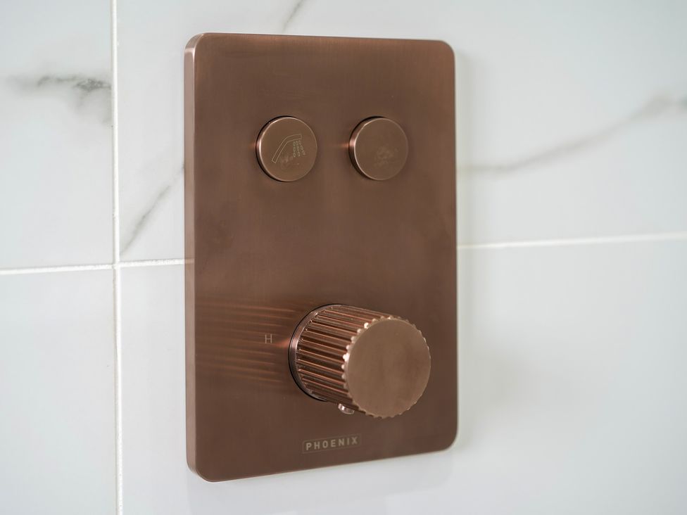 A shower control panel with temperature and water flow knobs at Northstone House Blackburn