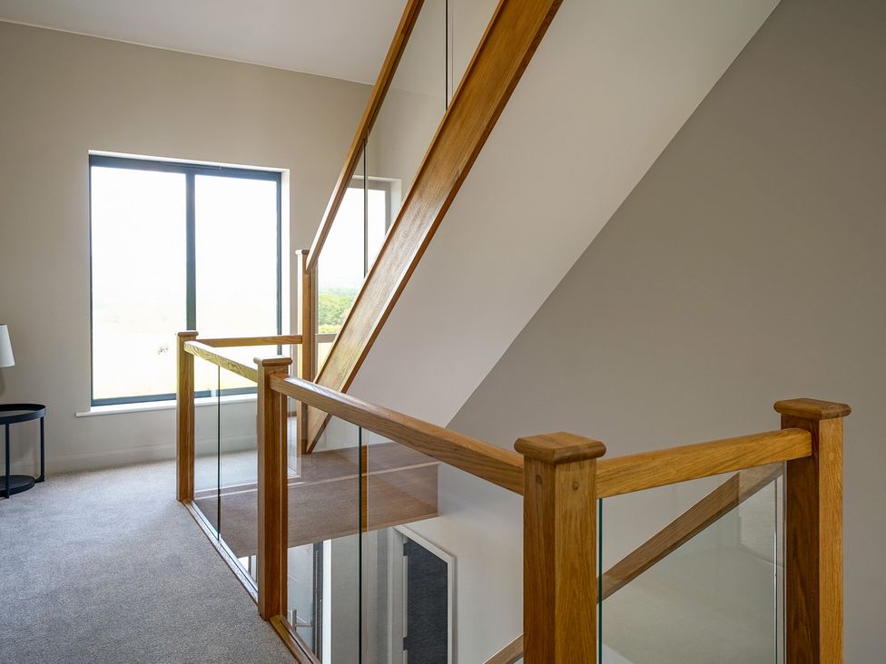 A staircase with wooden railing and window at Northstone House Blackburn