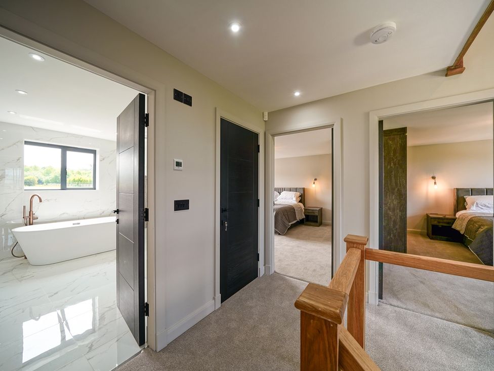 A hallway with doors leading to a bathroom and two bedrooms at Northstone House in Blackburn