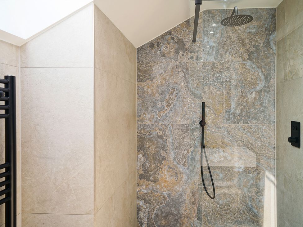 A shower with stone wall features at Northstone House Blackburn