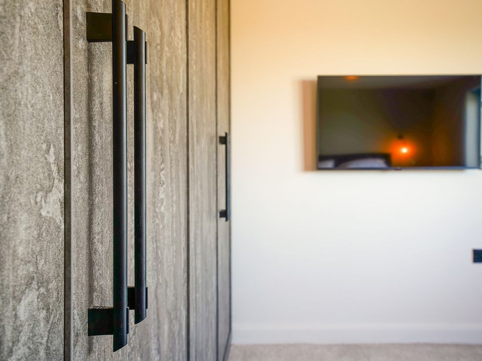 A bedroom with a wardrobe and a television at Northstone House Blackburn
