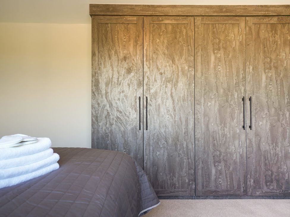 A bedroom with a wardrobe and towels at Northstone House Blackburn