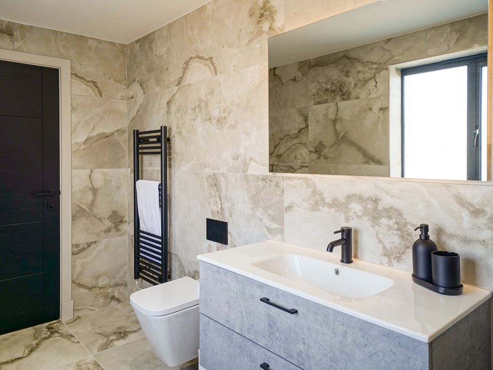 A bathroom featuring a sink, toilet, and towel radiator at Northstone House Blackburn
