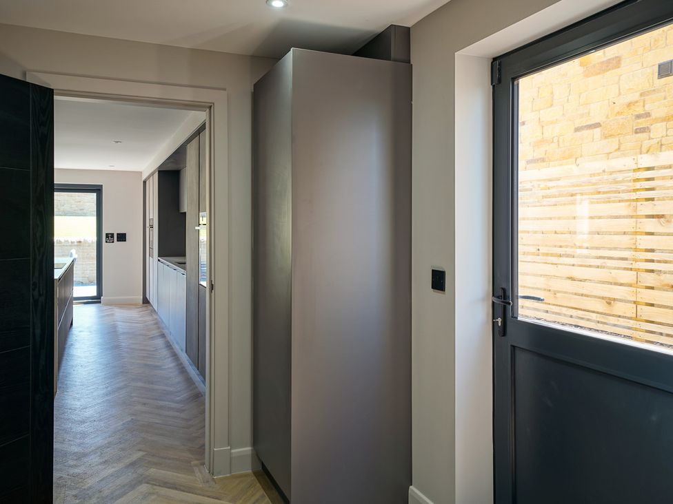 A kitchen with a fridge and door at Northstone House Blackburn