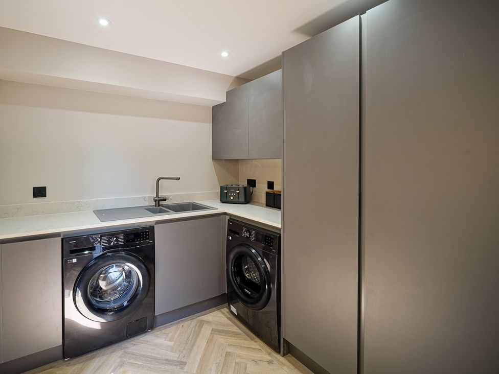 A laundry room with a washing machine and sink at Northstone House Blackburn