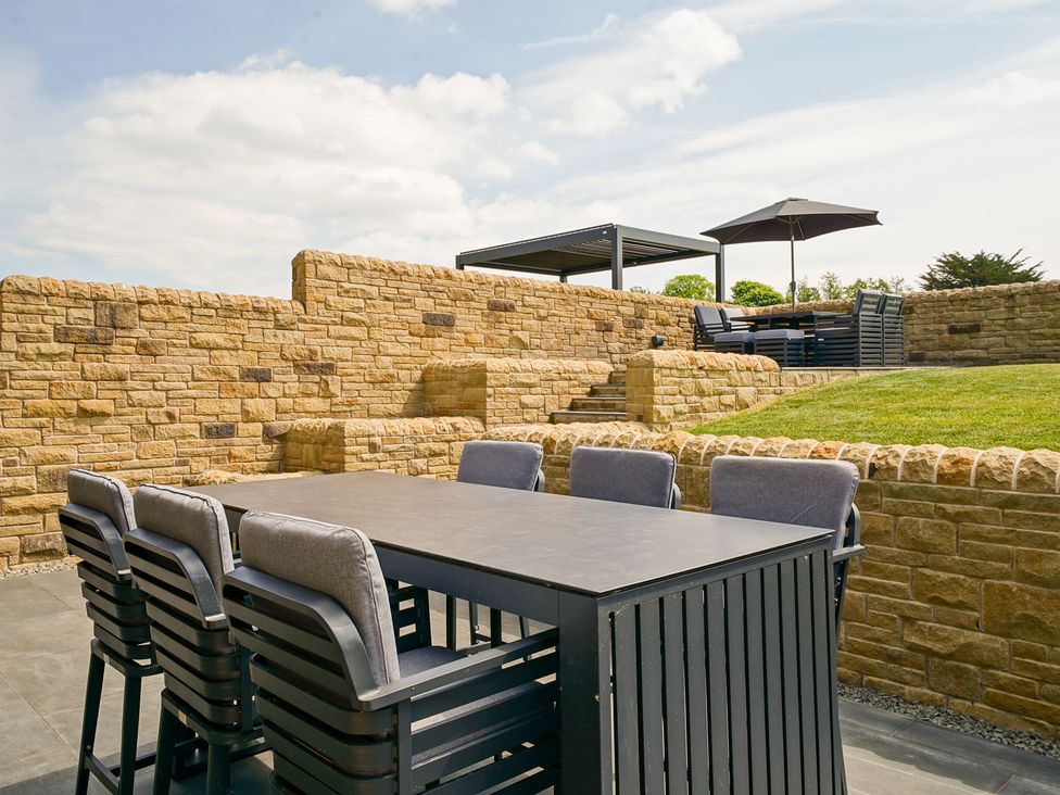 A patio with a table and chairs at Northstone House Blackburn