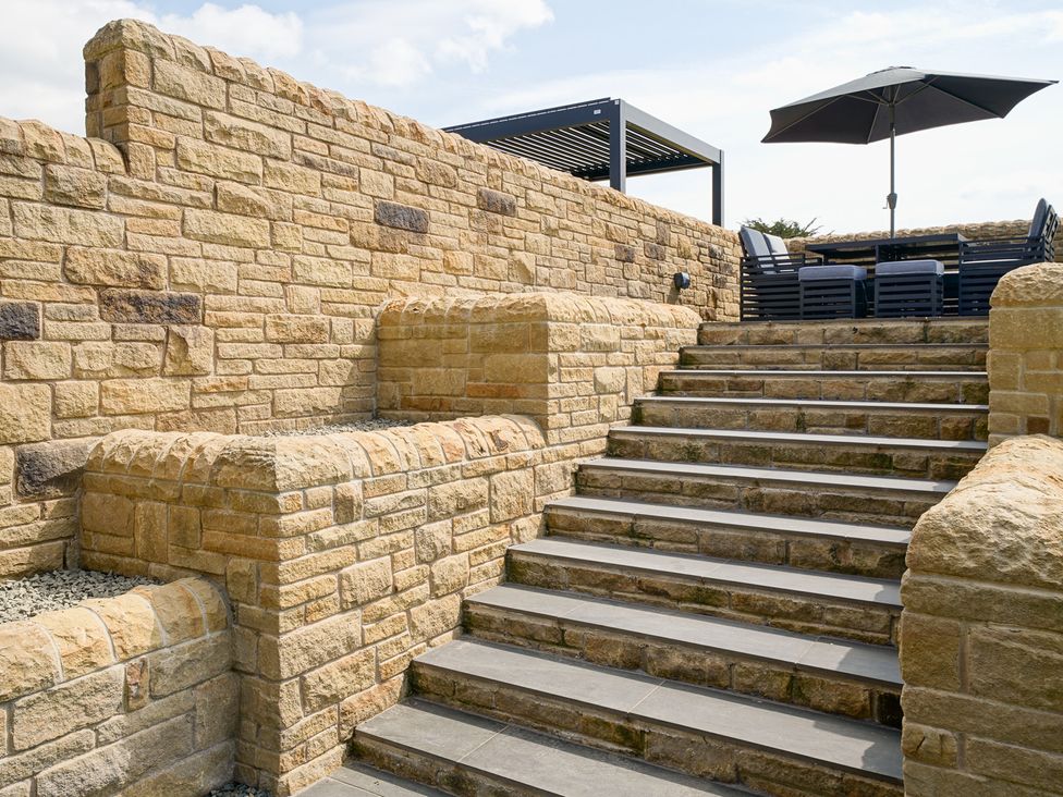 A garden with stone stairs and outdoor furniture at Northstone House Blackburn