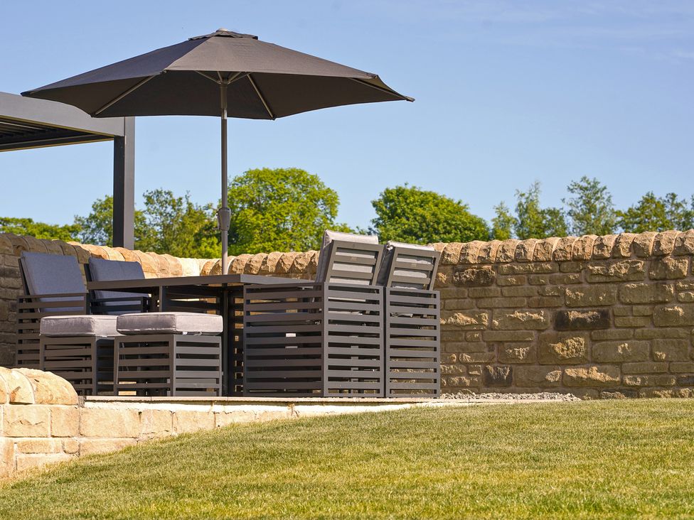 A garden with outdoor furniture and stone wall at Northstone House Blackburn