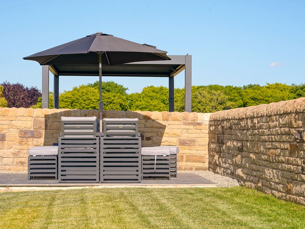 An outdoor seating area with an umbrella at Northstone House Blackburn