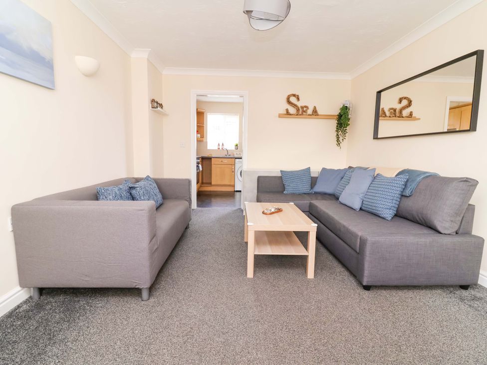 A living room with sofas and a coffee table at The Beach Escape in Prestatyn