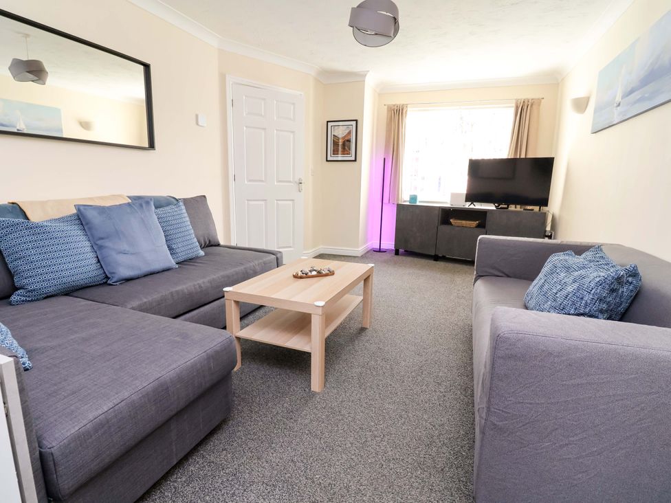 A living room with two sofas and a television at The Beach Escape in Prestatyn