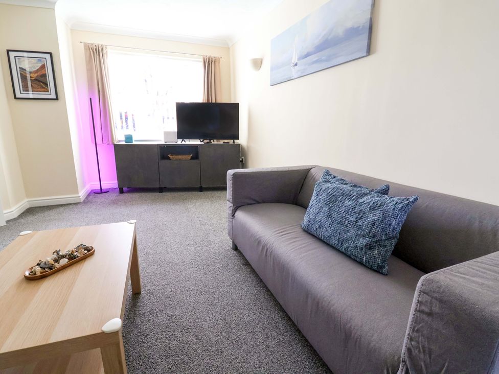A living room with a sofa and television at The Beach Escape in Prestatyn