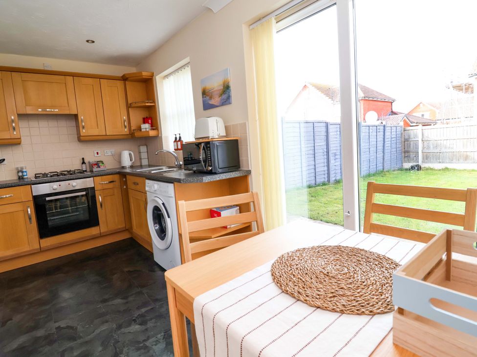 A kitchen with a dining table and appliances at The Beach Escape in Prestatyn