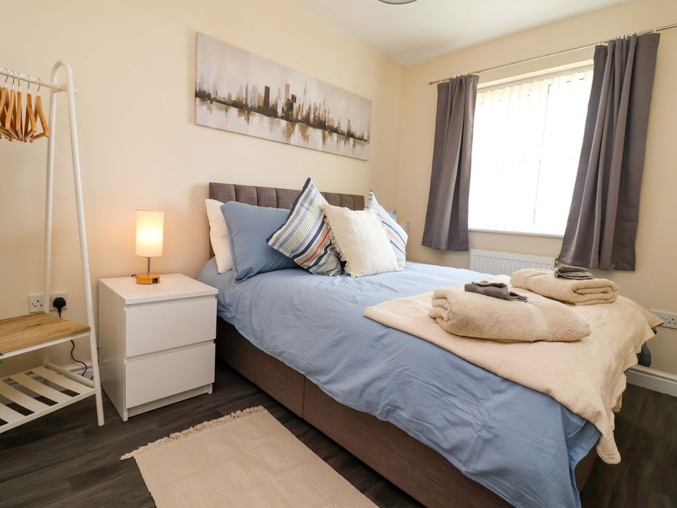 A bedroom with a bed and bedside table at The Beach Escape in Prestatyn