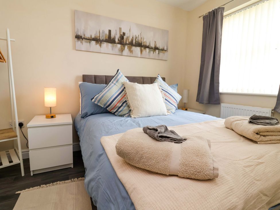 A bedroom with a bed and nightstand at The Beach Escape in Prestatyn