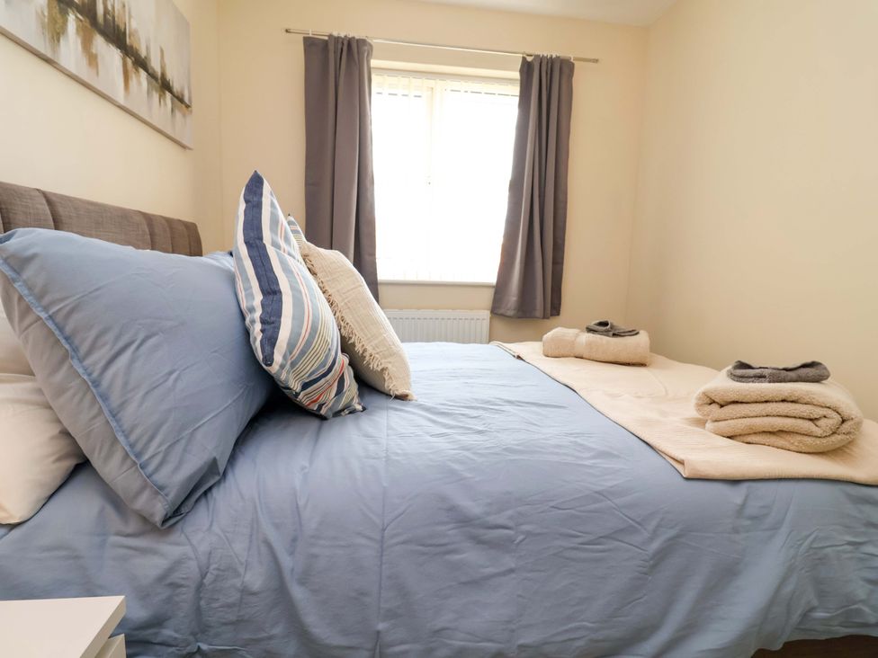A bedroom with a bed and towels on the side at The Beach Escape in Prestatyn