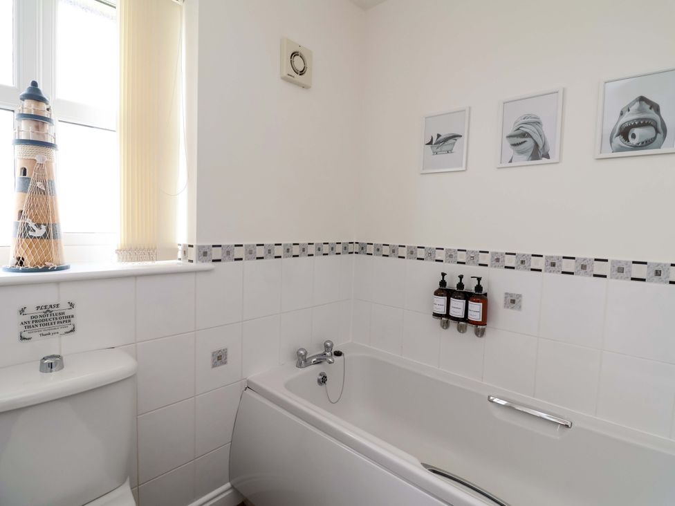 A bathroom with a bathtub and toilet at The Beach Escape in Prestatyn