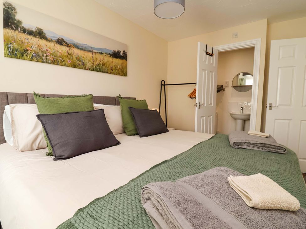 A bedroom with a bed and towels at The Beach Escape in Prestatyn