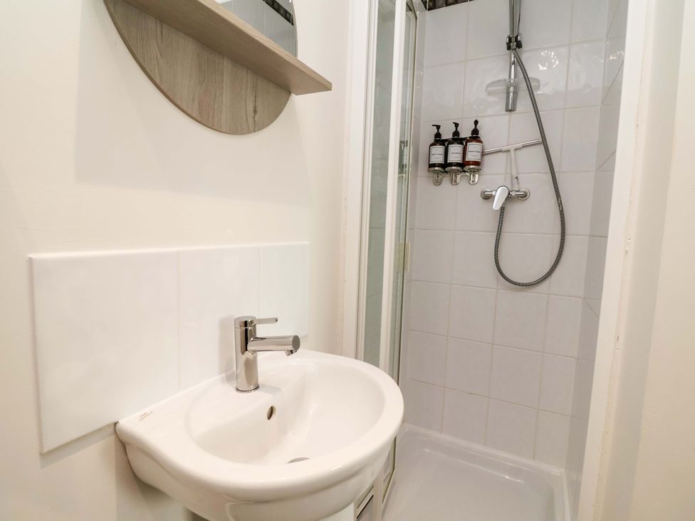 A bathroom with a shower and sink at The Beach Escape in Prestatyn