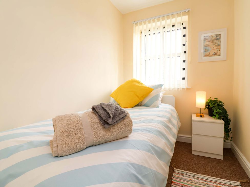 A bedroom with a bed and nightstand at The Beach Escape in Prestatyn