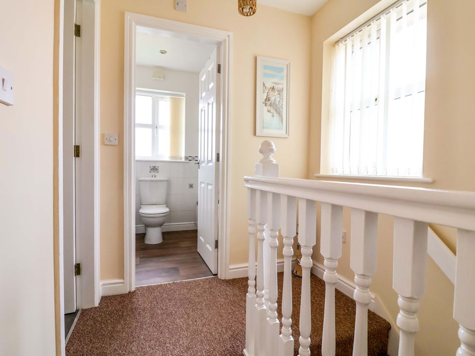 A hallway with a staircase leading to another room at The Beach Escape in Prestatyn